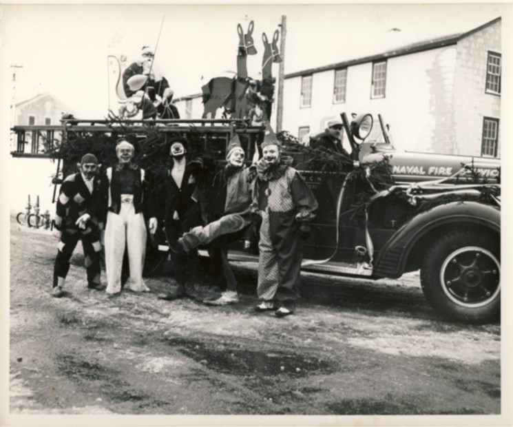 Image for Photograph of R.C.N. Naval Fire Service, fire engine made into a Christmas float with one Santa Claus and five clowns.