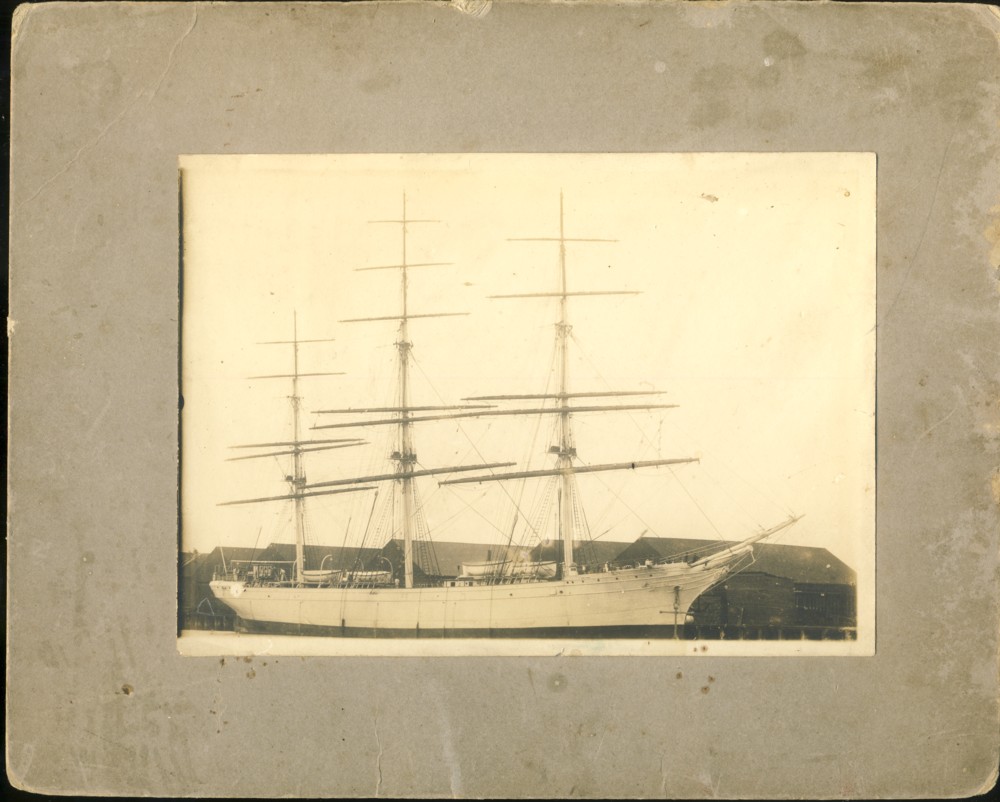 Image for Photograph of sailing ship at a wharf with warehouses in the foreground. Written in pencil on the verso is 'Ship at Shipyard, Bridgewater, Note Figurehead.'